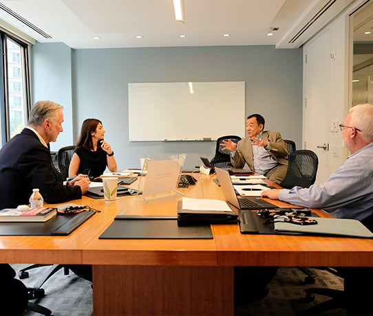 Coworkers collaborating around conference room table
