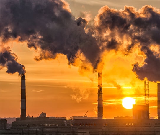 Factory creating pollution with sunset in the background