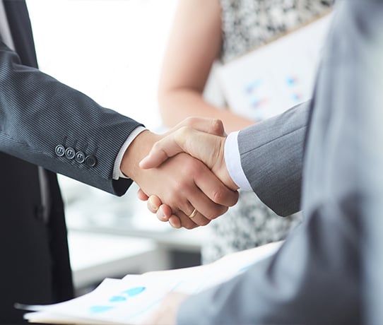 Close-up of handshake between two partners in suits