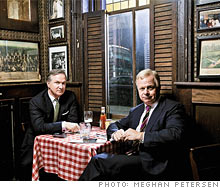 two men in suites sitting at restaurant 